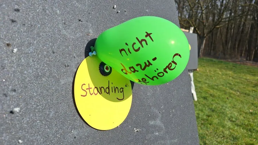 Standing vs dazugehören Ein Luftballon mit dem Text "nicht dazugehören" verdeckt eine Zielkarte mit dem Text "standing"